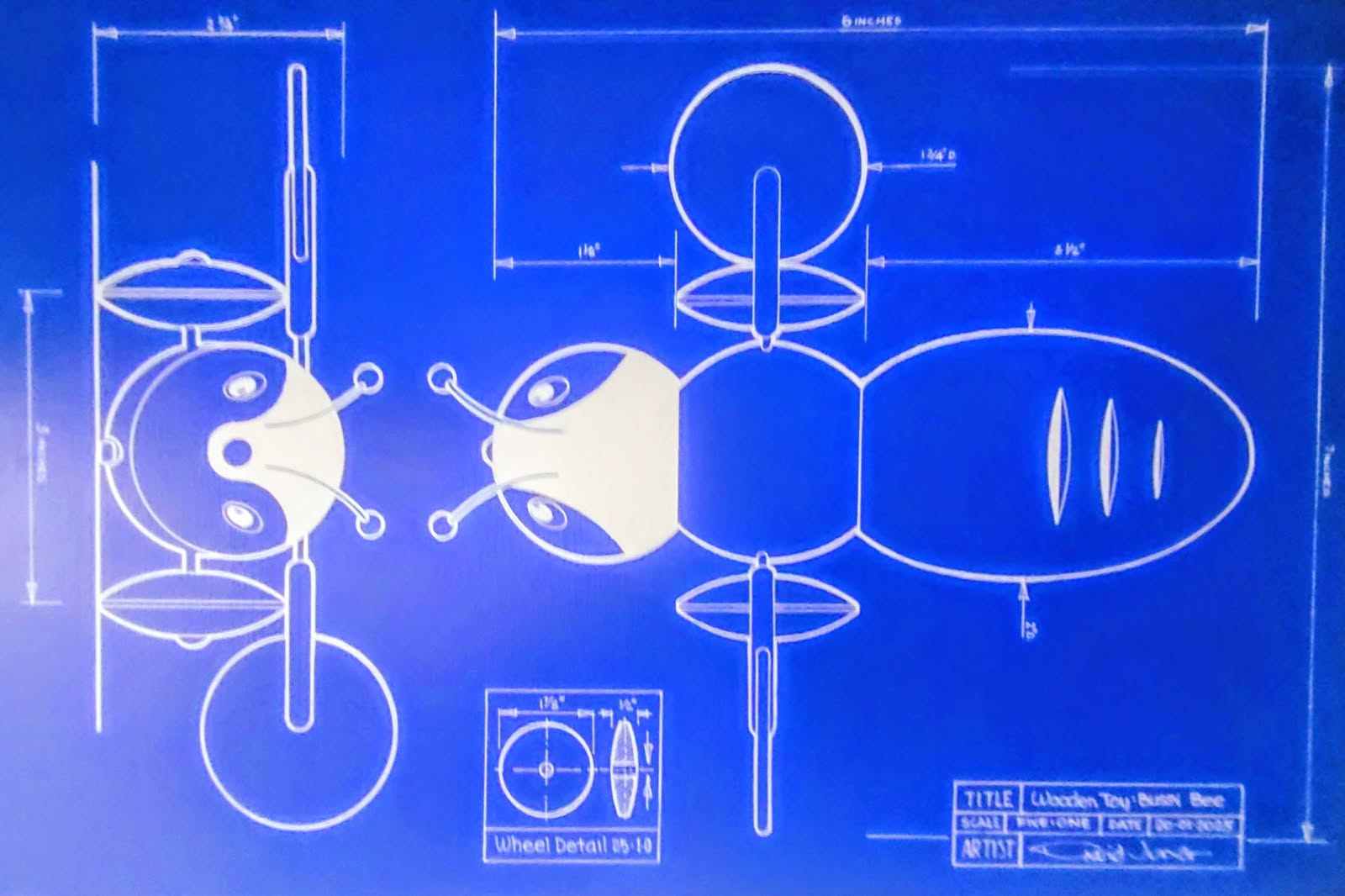 Blue technical drawing showing front, side and wheel details of a Buzzy Bee pull toy