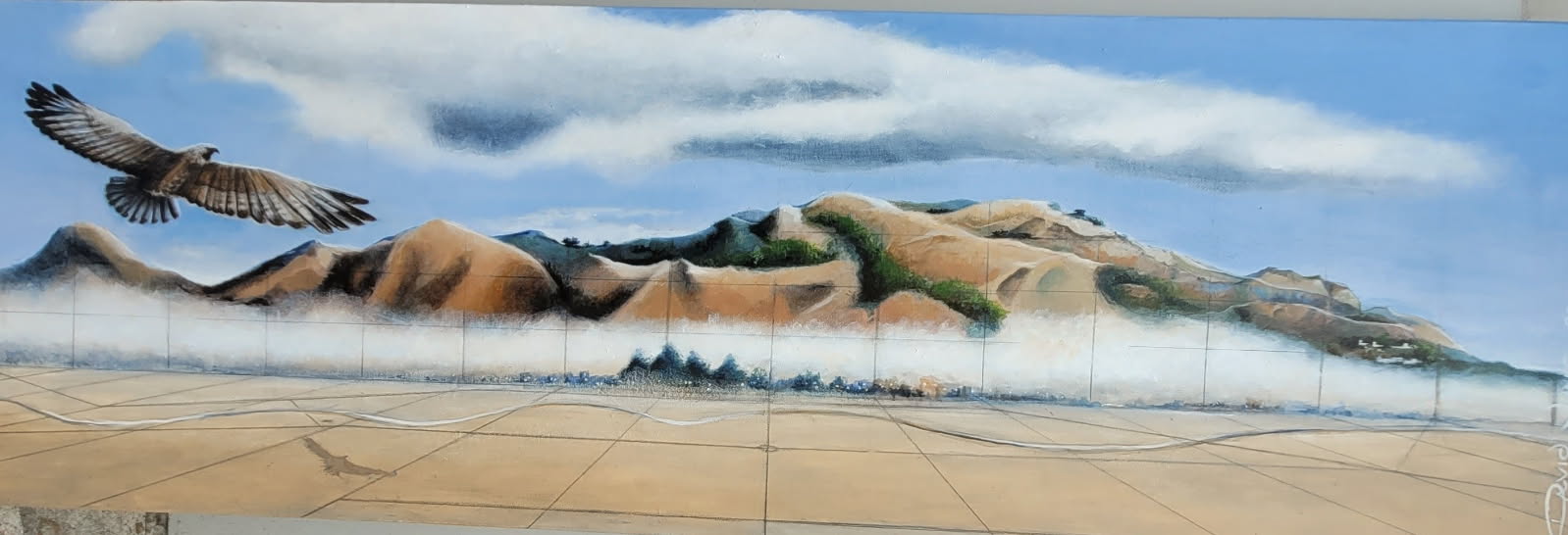 Panoramic painting of a falcon flying above fields and a mountain range