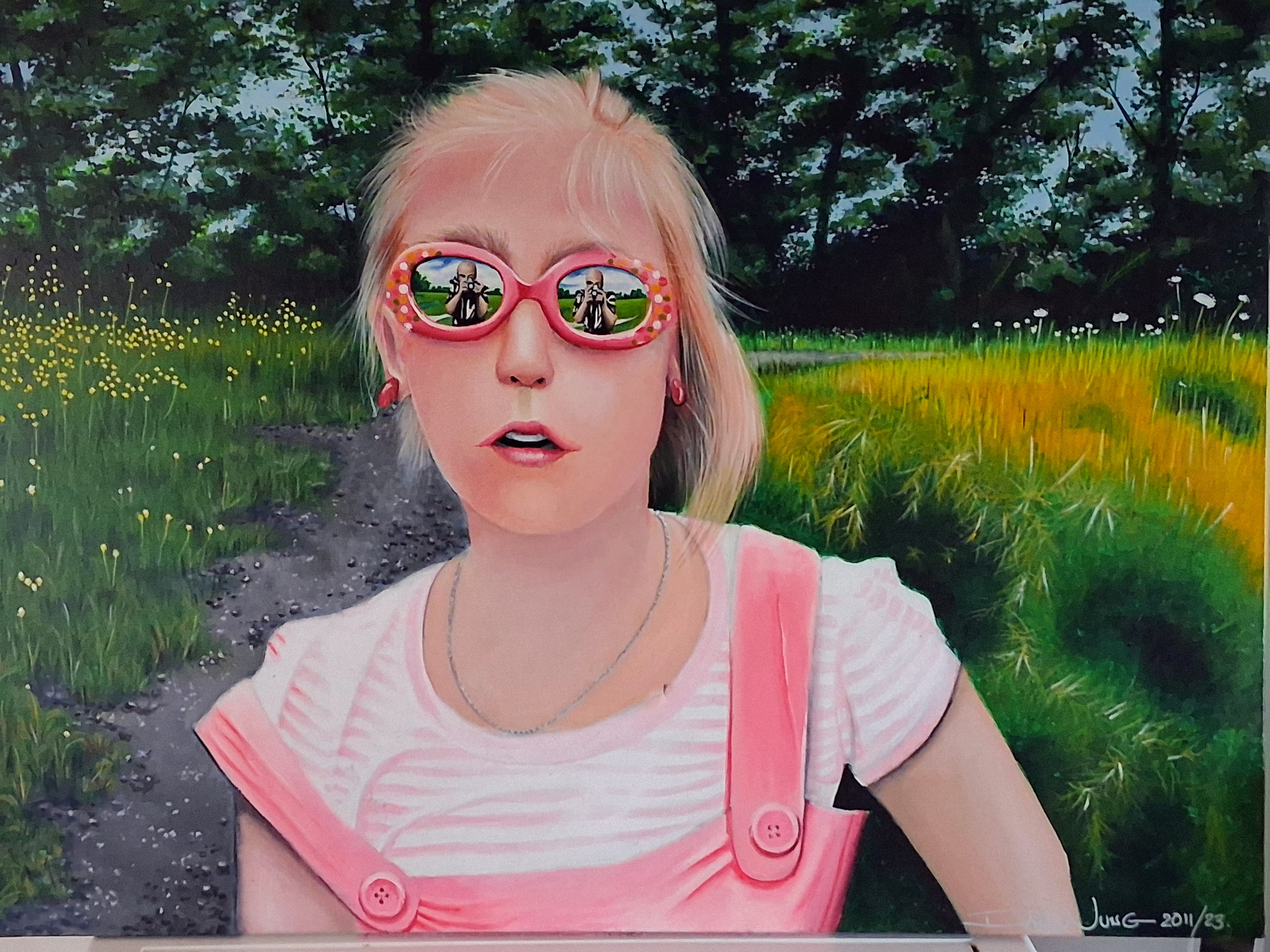 Portrait of a child in pink sunglasses in a field